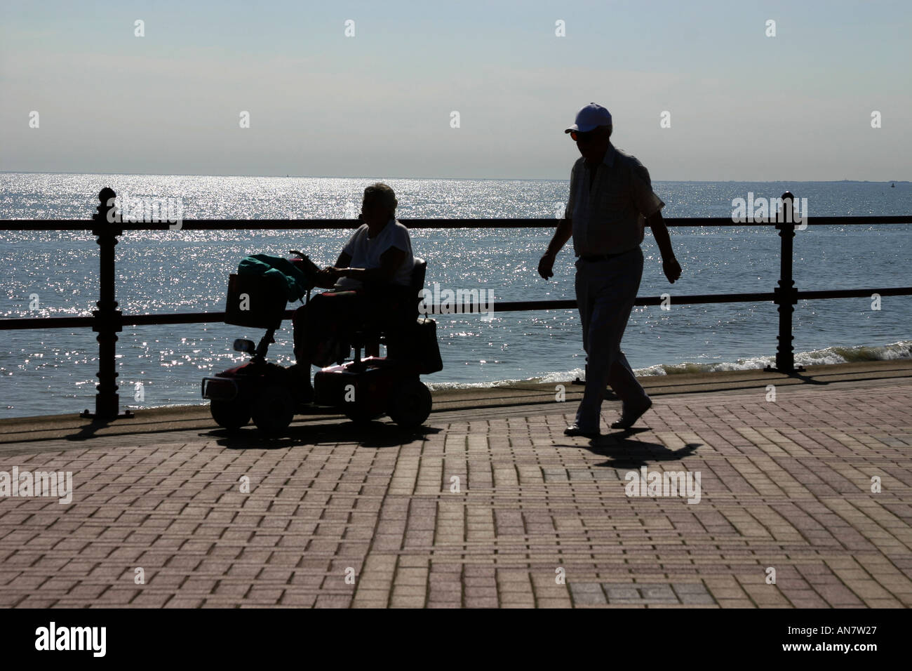 L uomo e la donna in sedia motability camminando lungo il lungomare di Bridlington in North Yorkshire Foto Stock