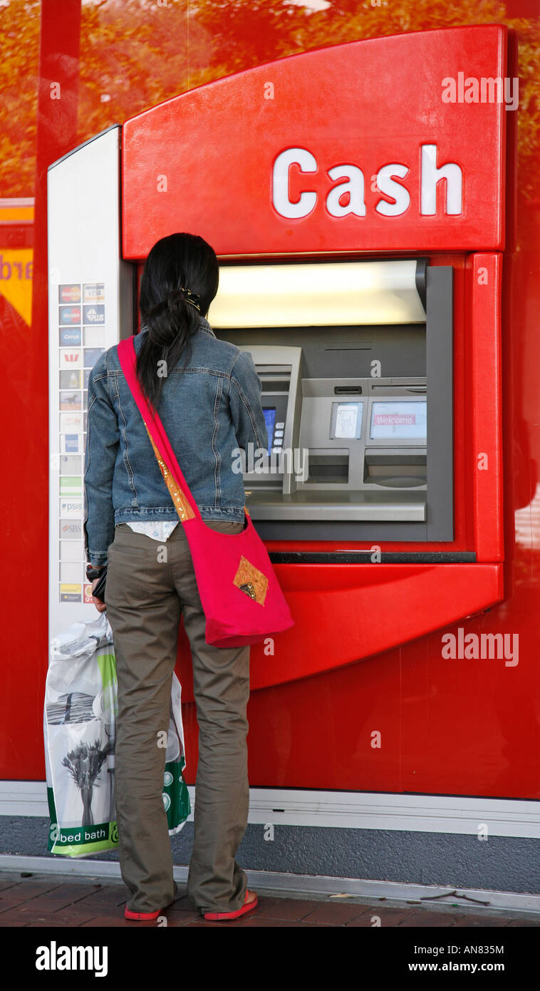 Donna che usando ATM Foto Stock