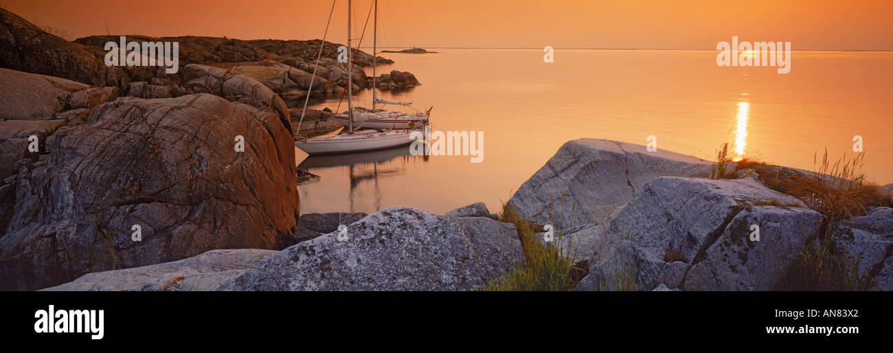 Barche a vela ancorata sulla piccola Lilla Nassa isola al tramonto in arcipelago di Stoccolma Foto Stock