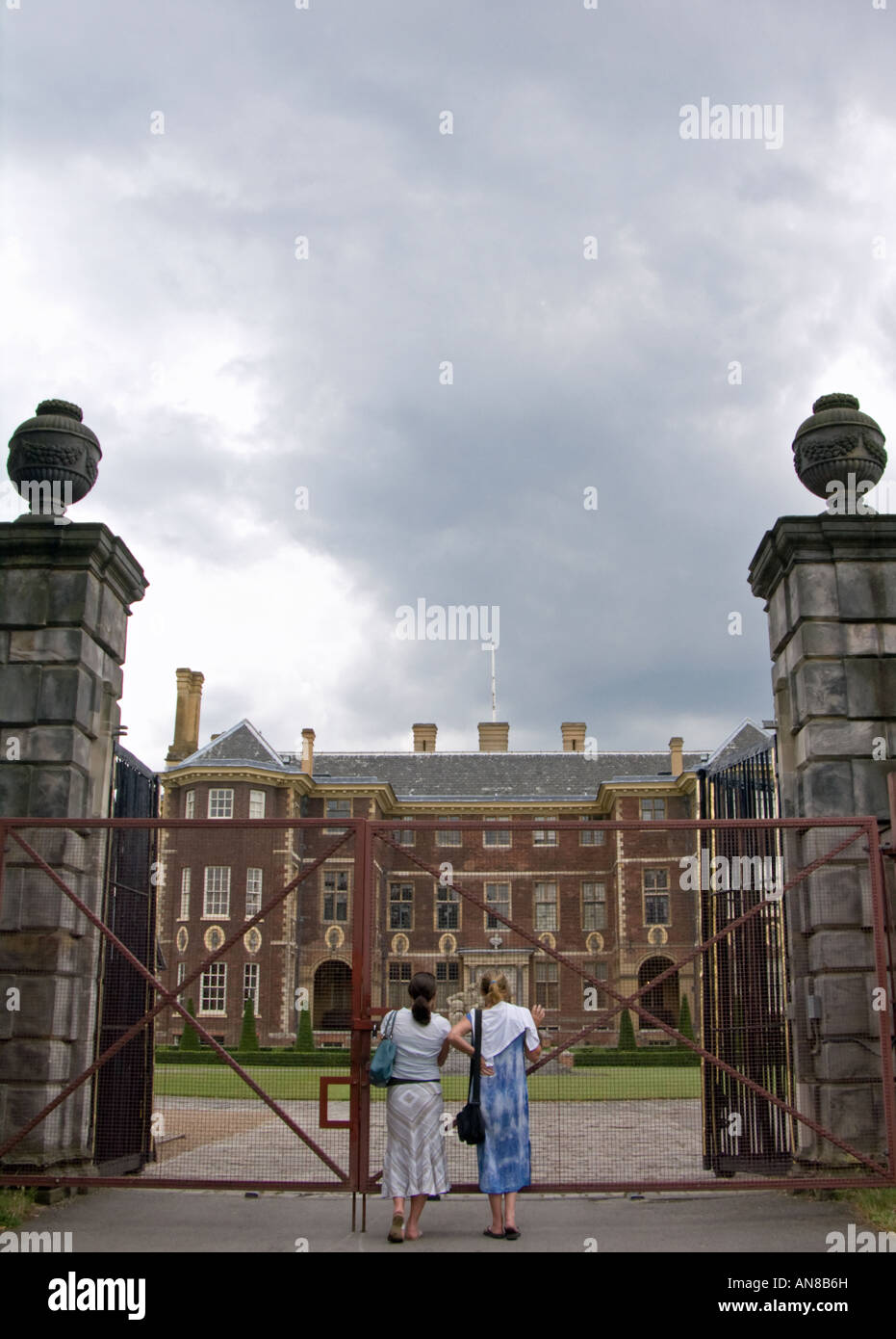 Due signore guardare attraverso i cancelli chiusi di ham casa, una residenza del XVII secolo nel prosciutto, Surrey, Inghilterra Foto Stock