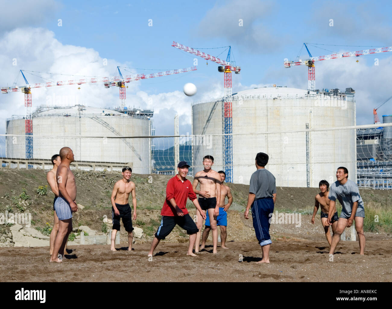 Gli uomini a giocare a beach volley in Aniva Bay isola di Sakhalin accanto al nuovo impianto GNL in costruzione 2006 Foto Stock
