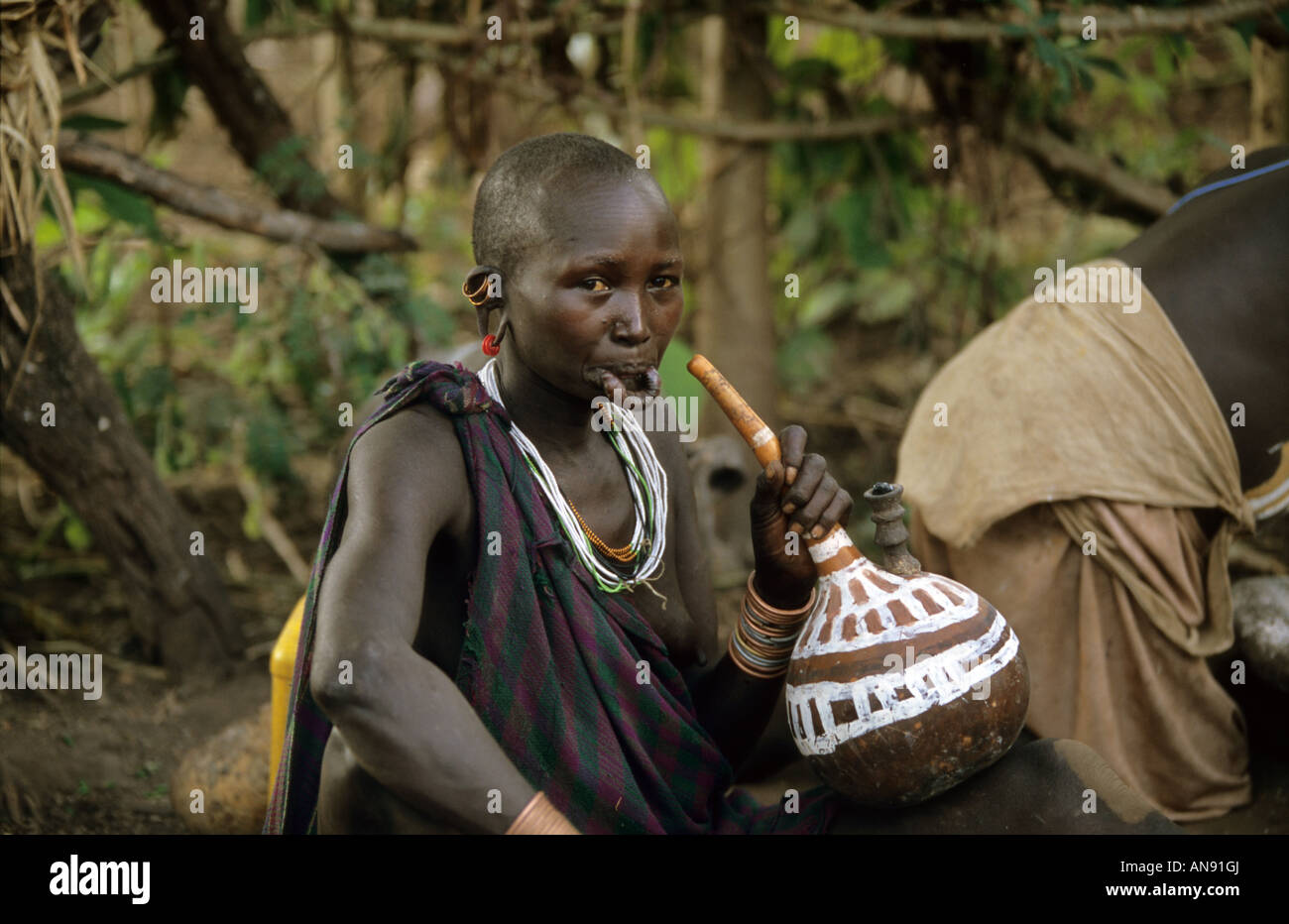 Una donna Surma avente un fumo nel suo tubo calabash Foto Stock