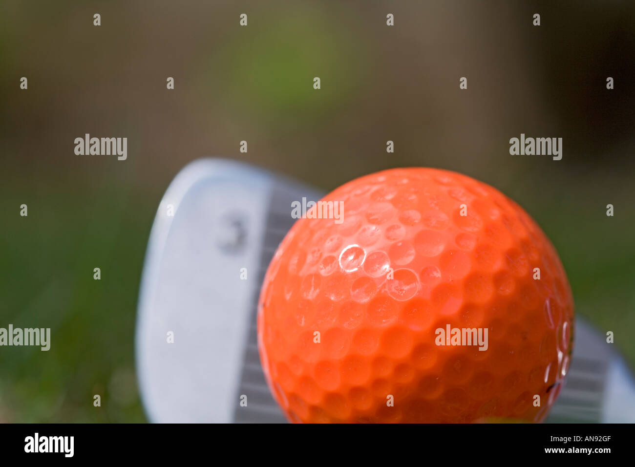 Spegnimento di rinvio 3 arancione ferro pallina da golf sul tee di legno Foto Stock