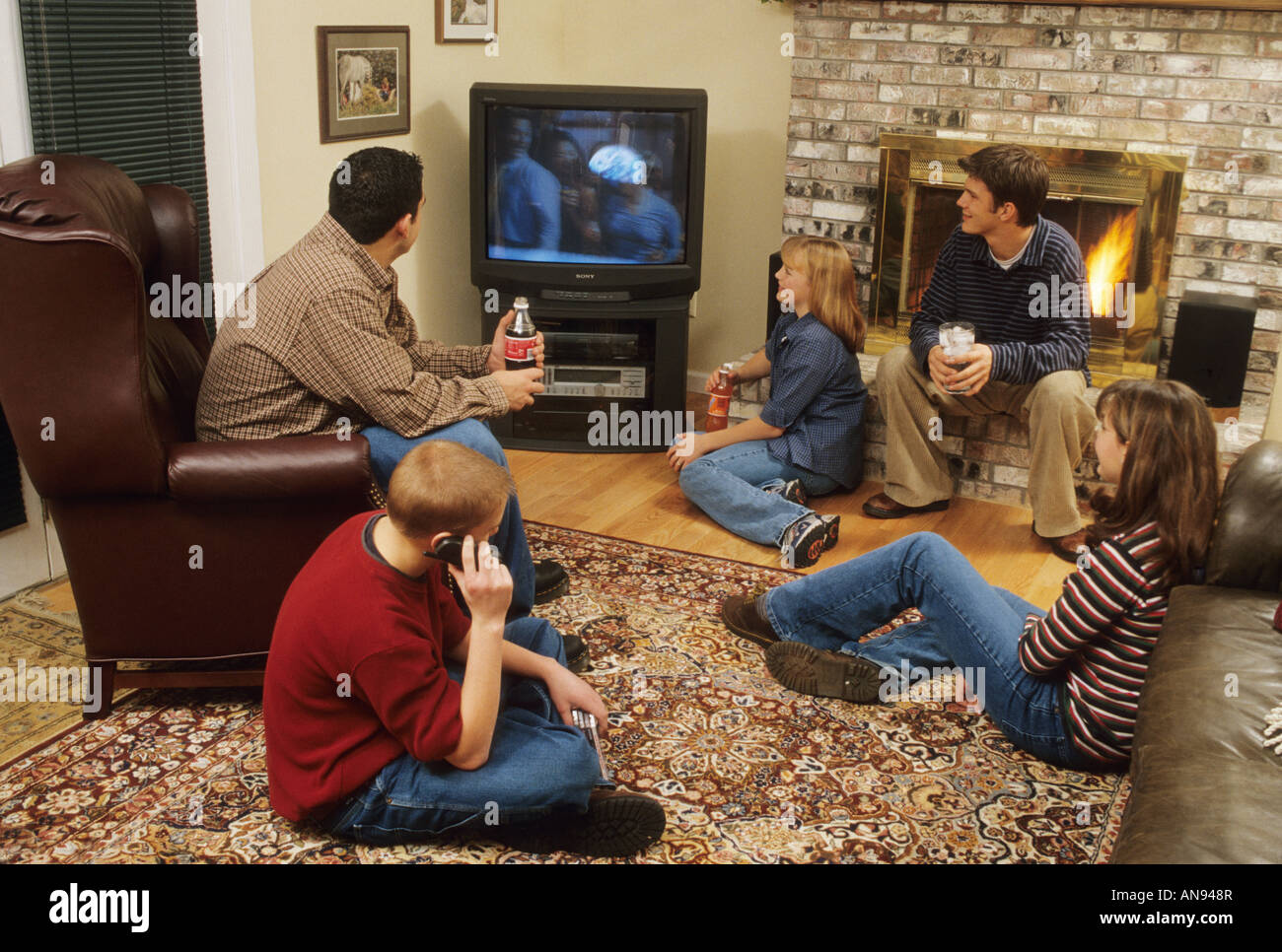 Ragazzi guardare la televisione tv mediante telefono cellulare OHIO USA living room home la vita appesa fuori dopo la scuola Foto Stock