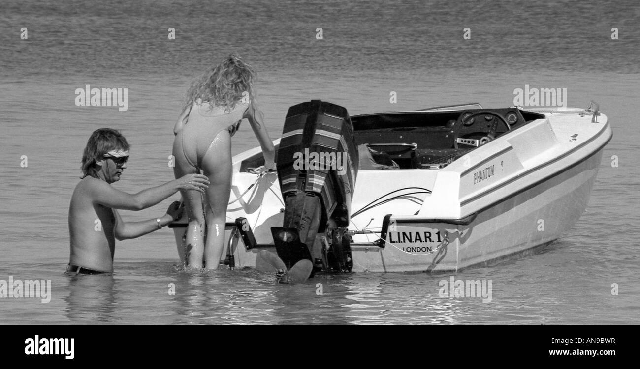 Uomo ragazza di dare una mano a salire sulla barca veloce a Palma Nova a Maiorca. Foto Stock