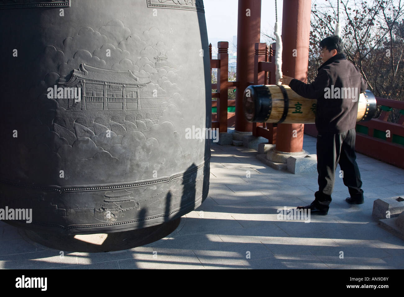 Uomo coreano squillo di avviso enorme campana Fortezza di Hwsaeong in Suwon Corea del Sud Foto Stock