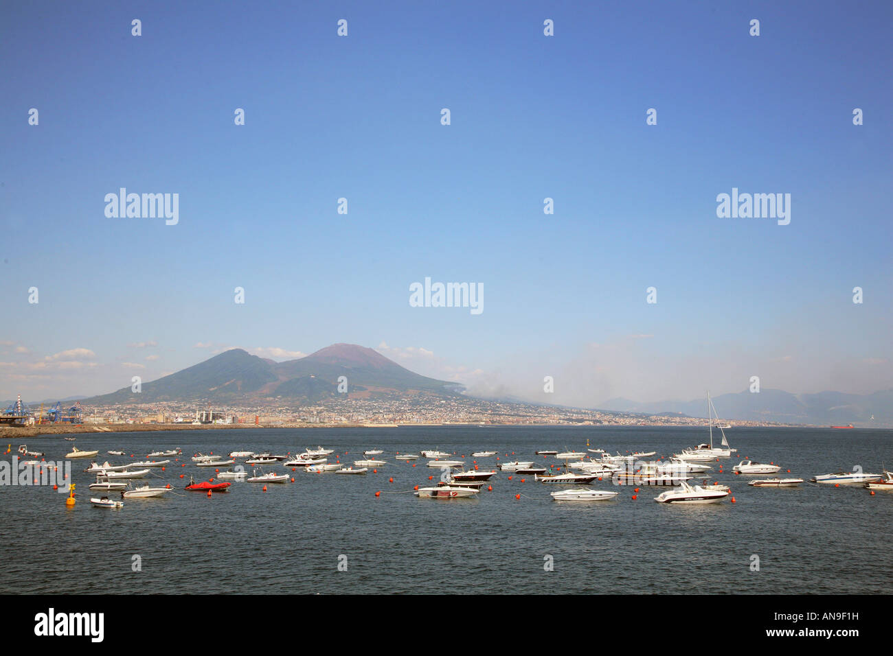 Barche ormeggiate in mare con il Vesuvio sullo sfondo Napoli Italia Foto Stock