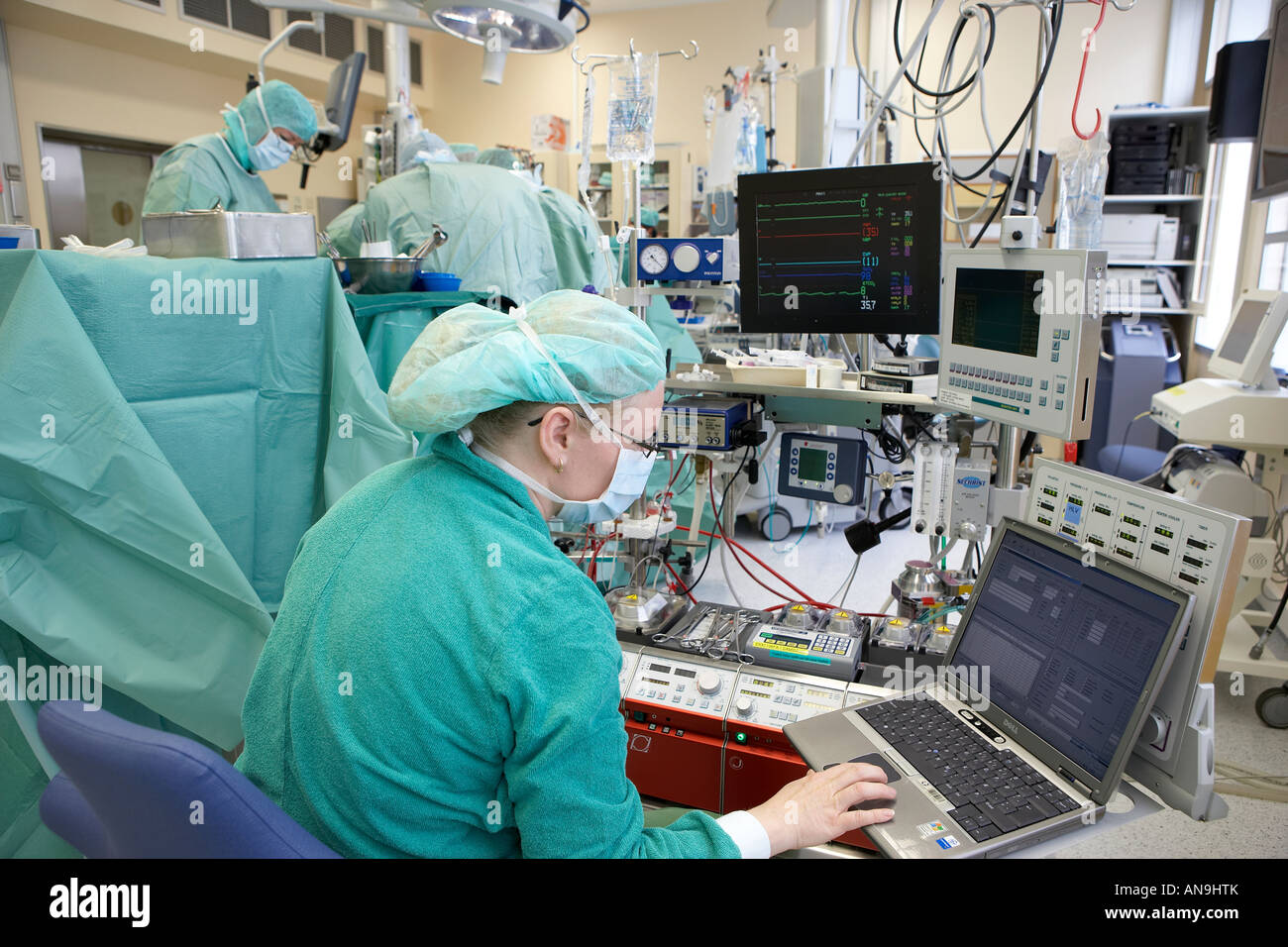 Il team chirurgico osservando i progressi sul monitor medici e il computer portatile Foto Stock