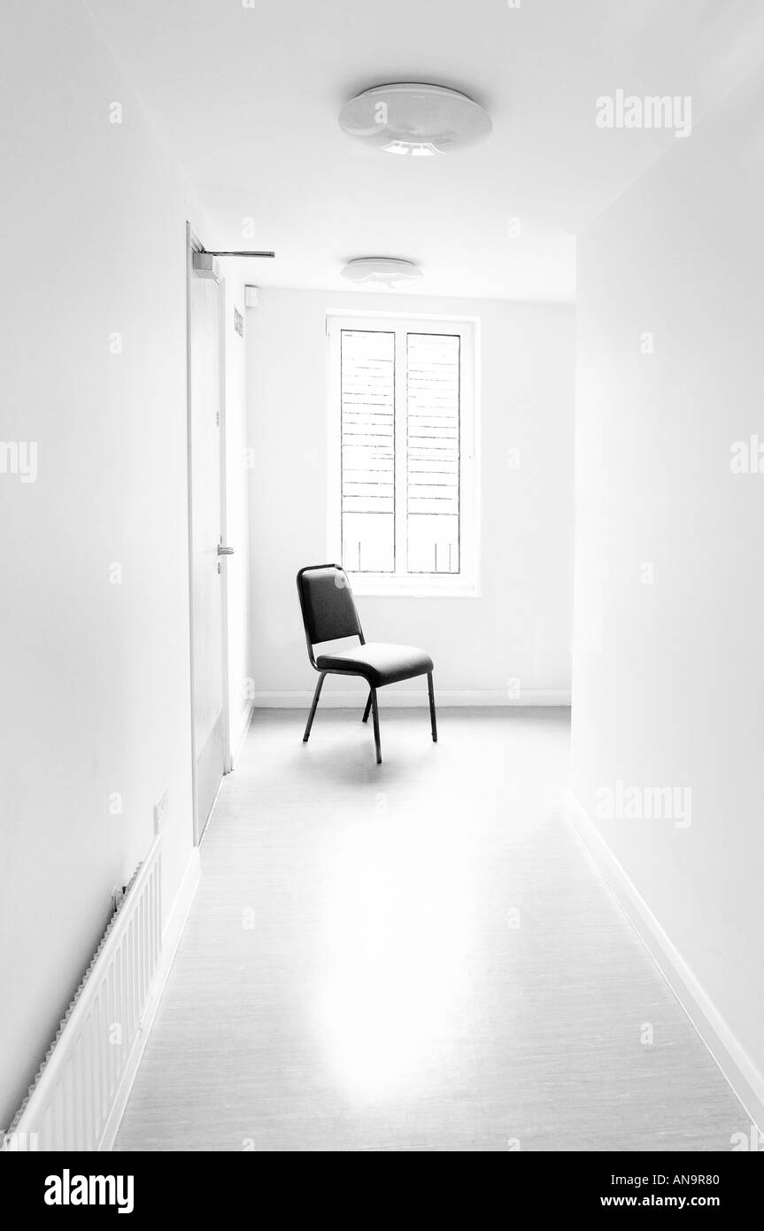 Sedia in un molto sterili e puliti cercando corridoio bianco appare come un asilo di qualche tipo o eventualmente ospedale Foto Stock