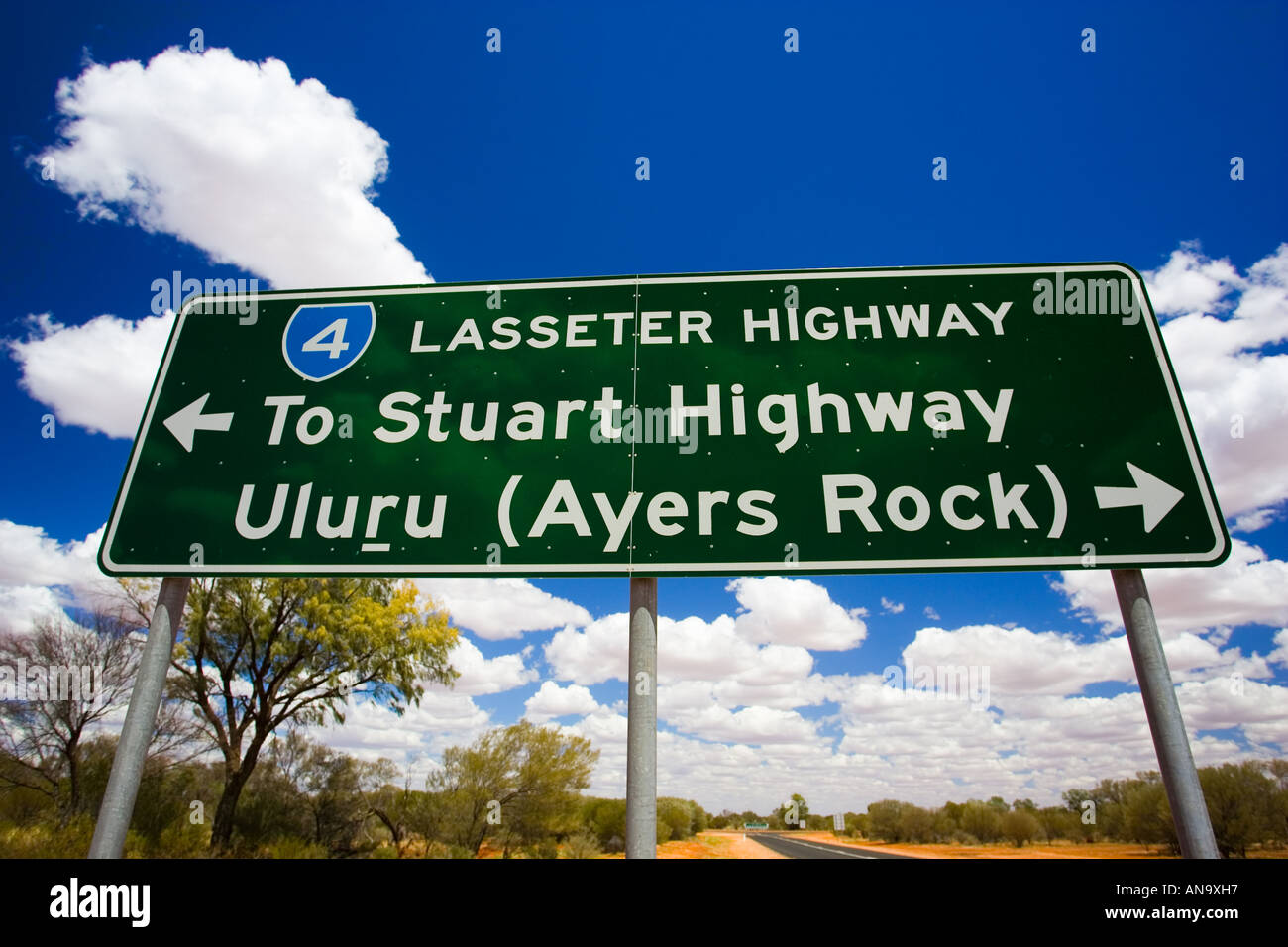 Lasseter highway sign di Stuart Highway e Uluru Ayers Rock di Territorio del Nord Australia Foto Stock