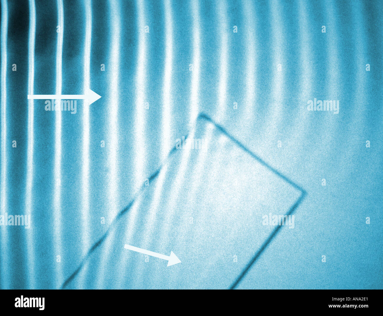 La rifrazione di onde di acqua che va dal profondo di acqua poco profonda in un serbatoio di ripple con una freccia per indicare il senso di marcia Foto Stock