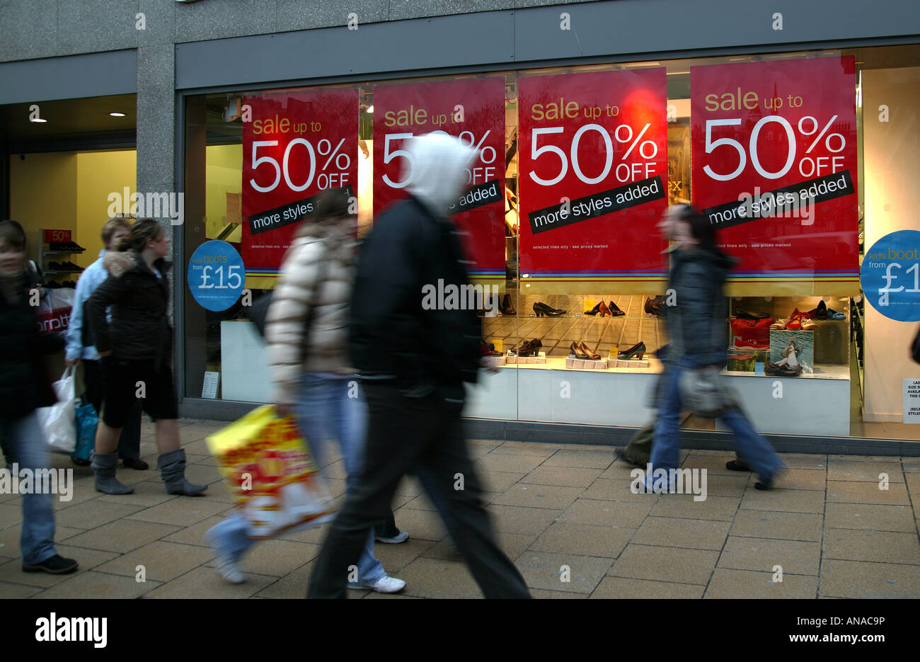 Vetrina vendita segni con il passaggio di pedoni sfocata in primo piano, Edimburgo, Scozia Foto Stock