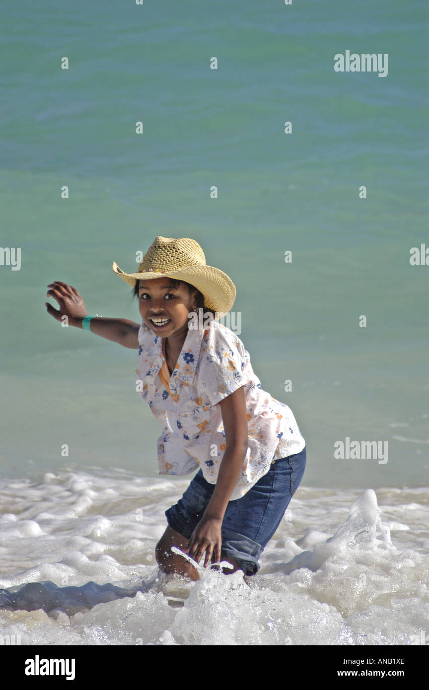 Bahamas ragazza delle Bahamas nel cappello di paglia in ballo nel surf Foto Stock
