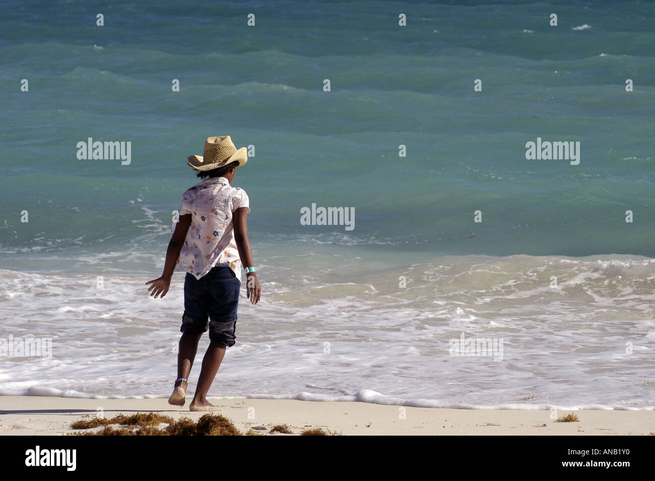 Bahamas ragazza delle Bahamas nel cappello di paglia in ballo nel surf Foto Stock