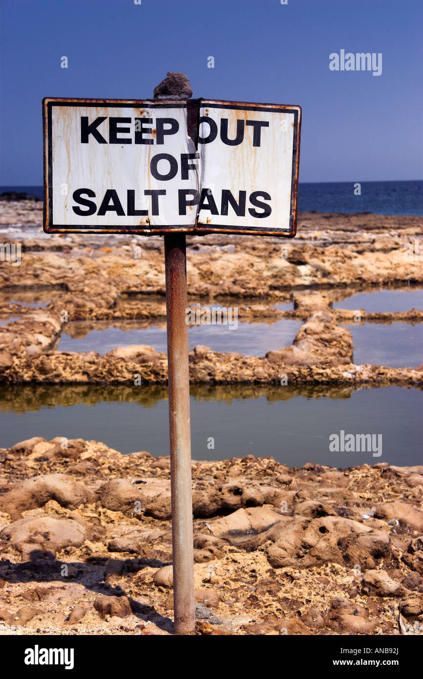 Saline utilizzate nella produzione di sale marino con Notice "tenere fuori saline", Baia di Xwieni, Gozo, Malta, Europa Foto Stock