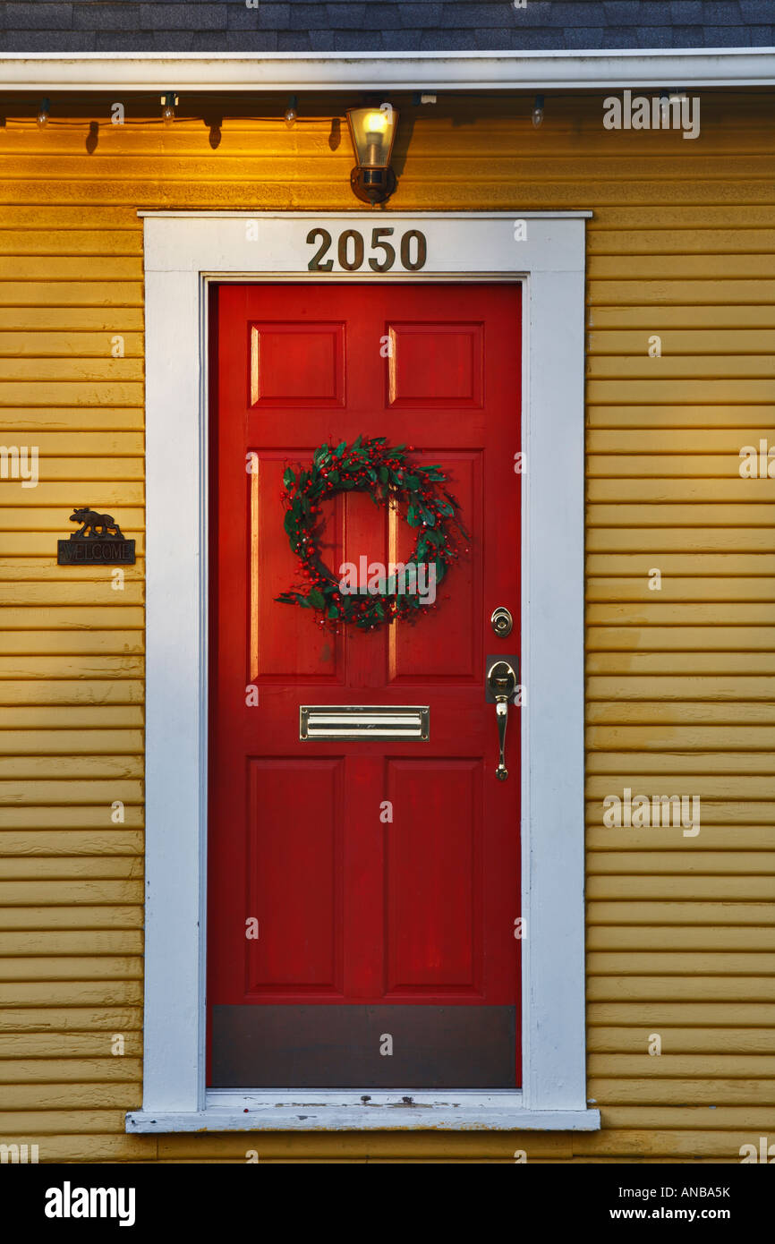 Natale holly corona sul distintivo porta di rosso e di giallo rifilato casa Victoria British Columbia Canada Foto Stock