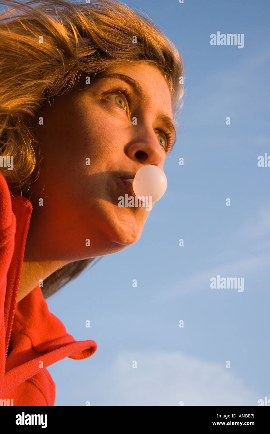 Giovane donna soffiando bolla con la gomma da masticare Foto Stock