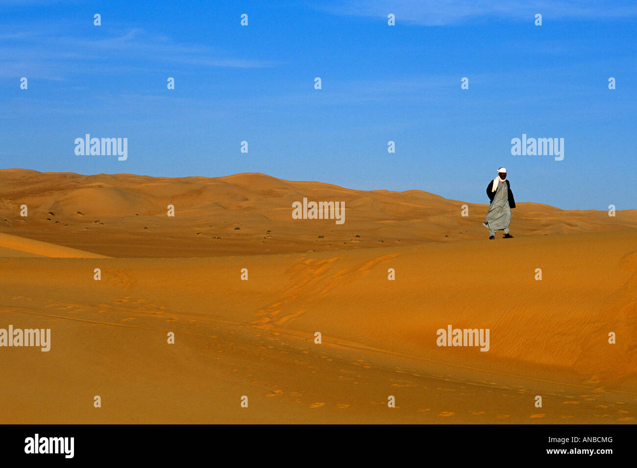 Il Tuareg uomo a camminare sulle dune di Erg Awbari Foto Stock