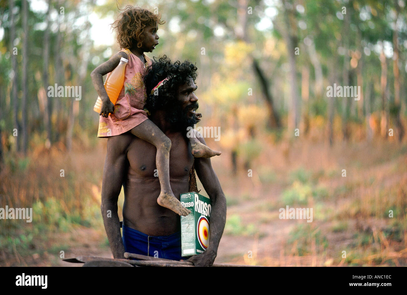 Charlie porta la sua figlia sua spears ed il detersivo in polvere torna al suo campo remoto nella boccola in corrispondenza Mormega Arnhem Land Foto Stock
