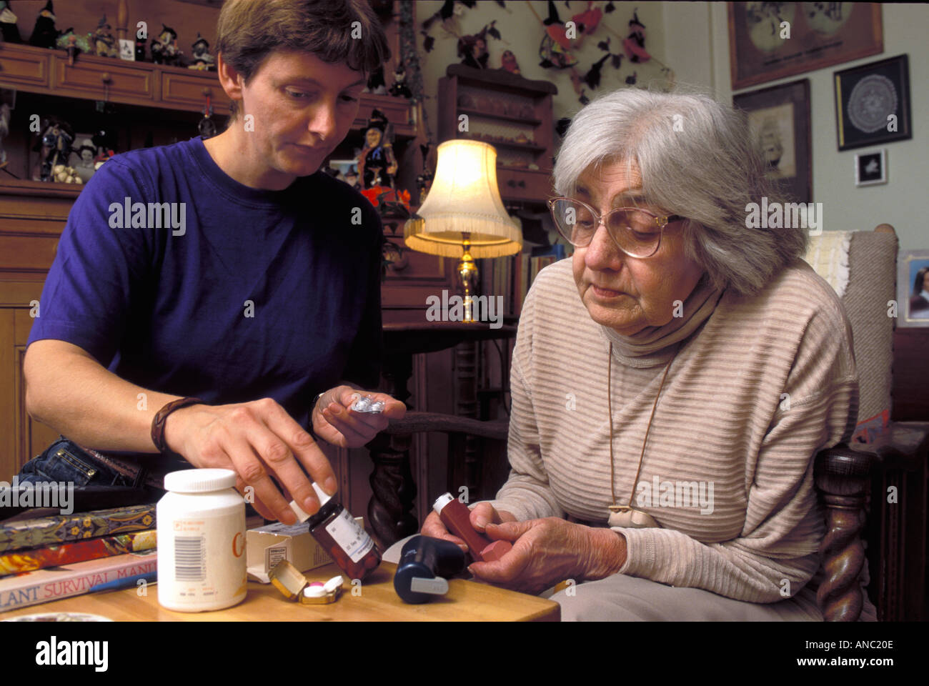 Donna anziana nella propria casa di essere aiutato con le sue pillole e medicinali per un caregiver REGNO UNITO Foto Stock