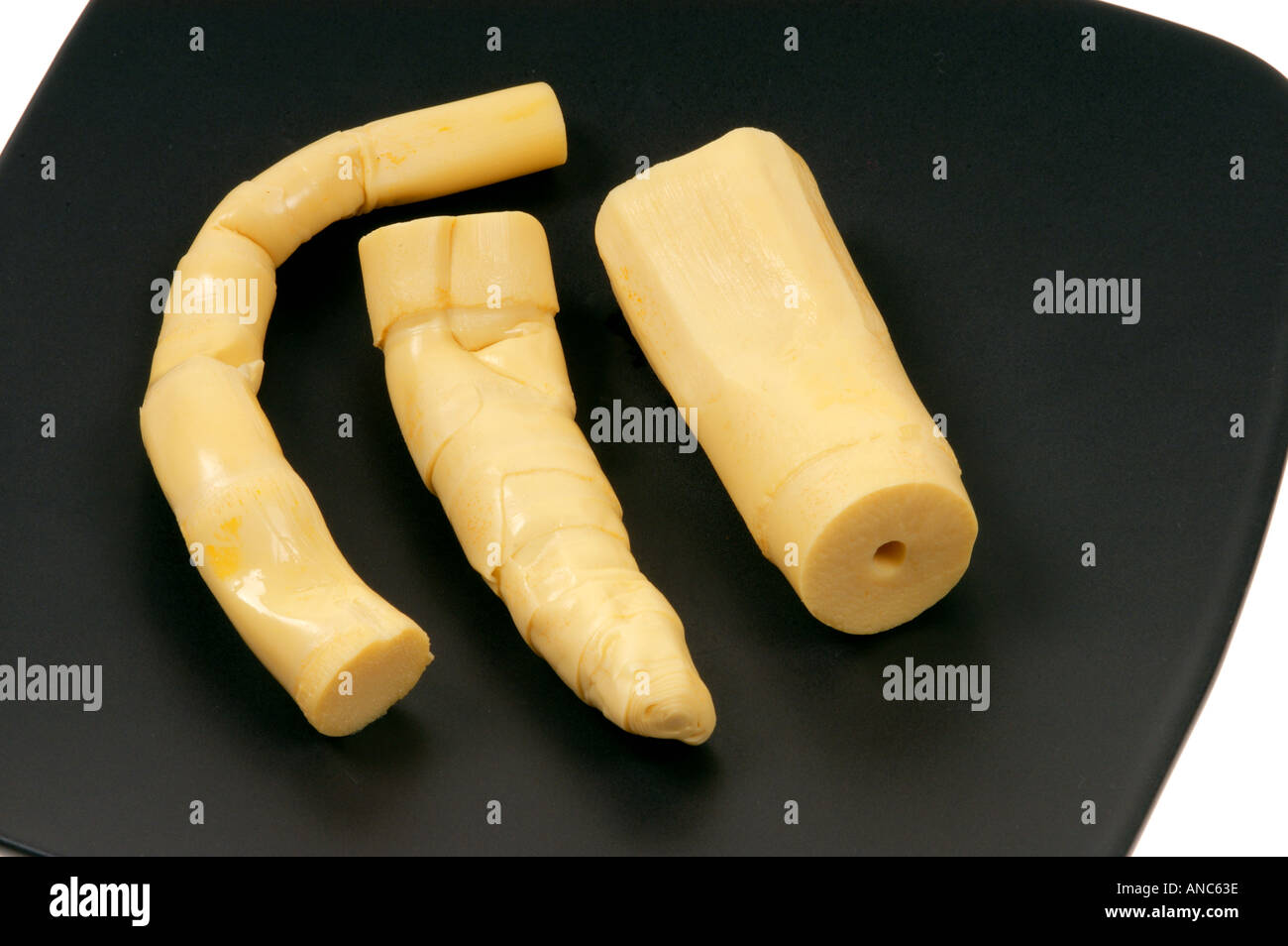 Germogli di bambù per mangiare sulla piastra nera pezzi tagliati dei tagli Foto Stock