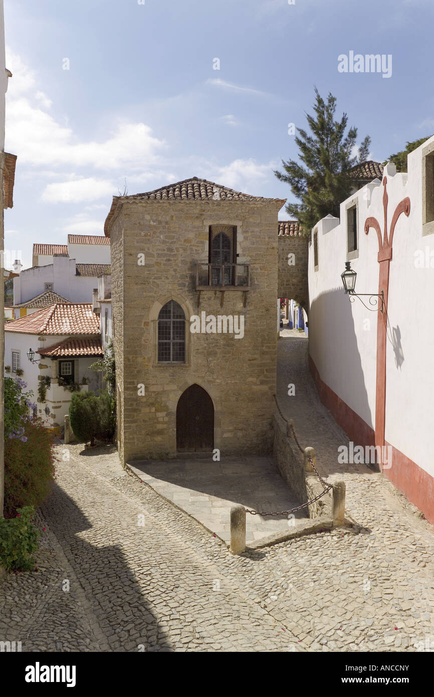 Il Portogallo, Costa Da Prata, Estremadura, Obidos medievale città murata. Una stretta strada di ciottoli con un antica casa gotica Foto Stock