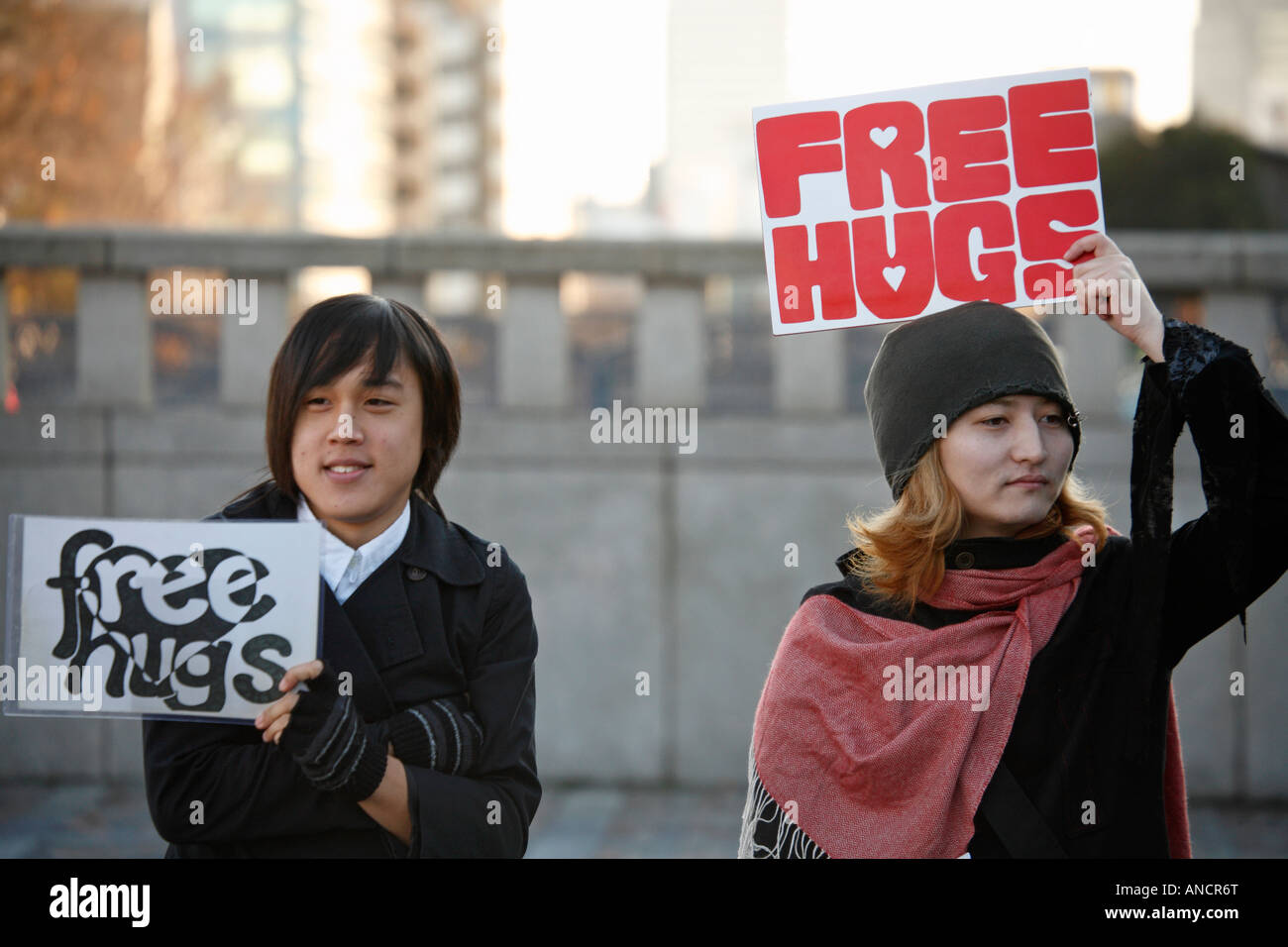 Gli adolescenti tenendo su Free Hugs segni, Harajuku, Tokyo, Giappone Foto Stock