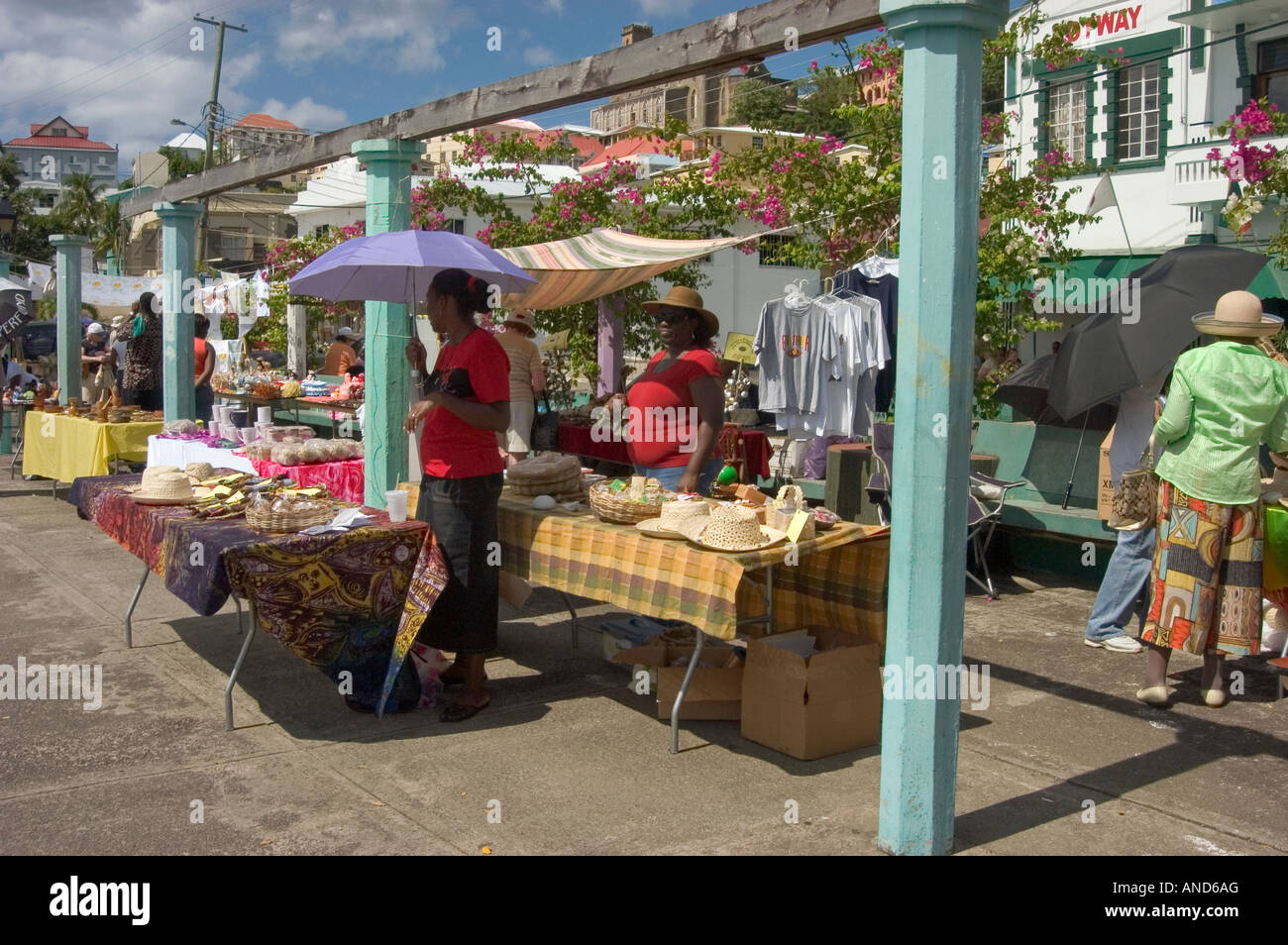 Stallholder riparo dal sole sotto un ombrellone in St. Georges, Grenada, dei Caraibi Foto Stock