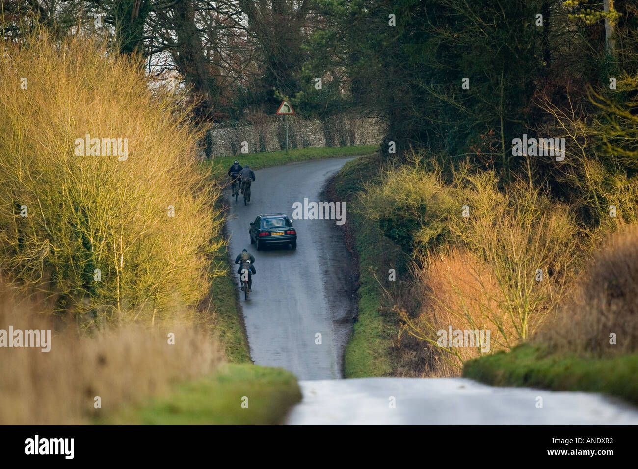Auto supera i ciclisti su strada di campagna vicino a Burford Regno Unito Foto Stock