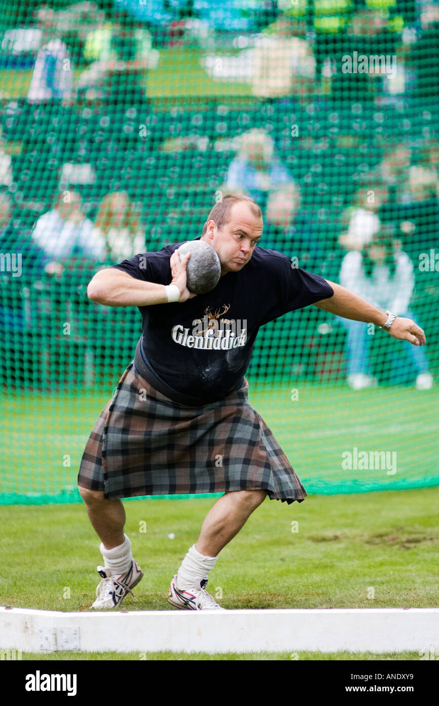 L'uomo compete nel colpo messo a concorso i giochi Braemar Highland Gathering Scozia UK Foto Stock