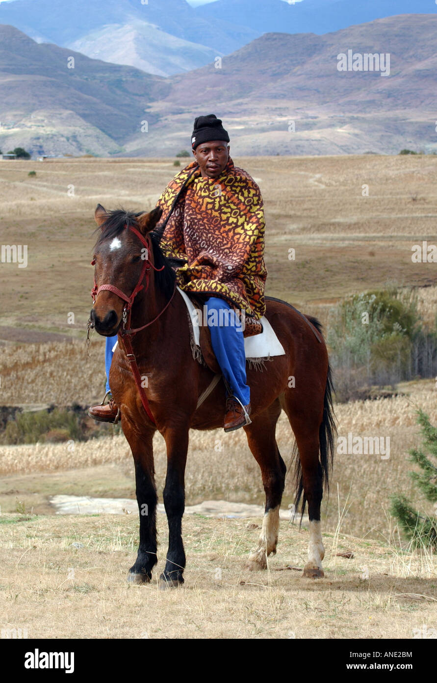 Un uomo vestito in un tradizionale basotho coperta sui horeseback in Lesotho, Sud Africa Foto Stock