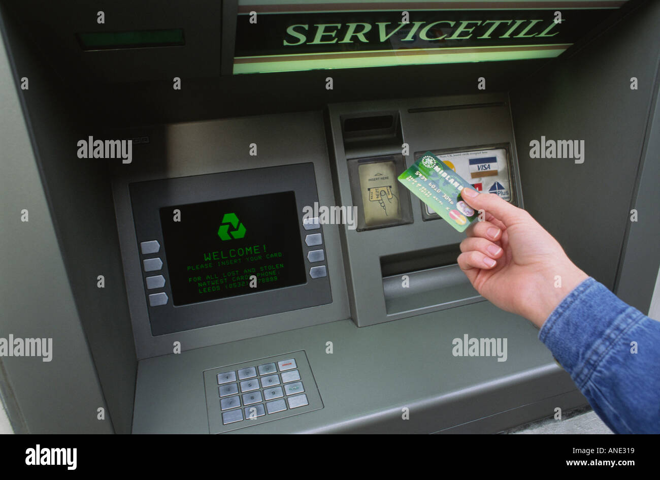 Mans mettendo mano carta in un bancomat. Foto Stock