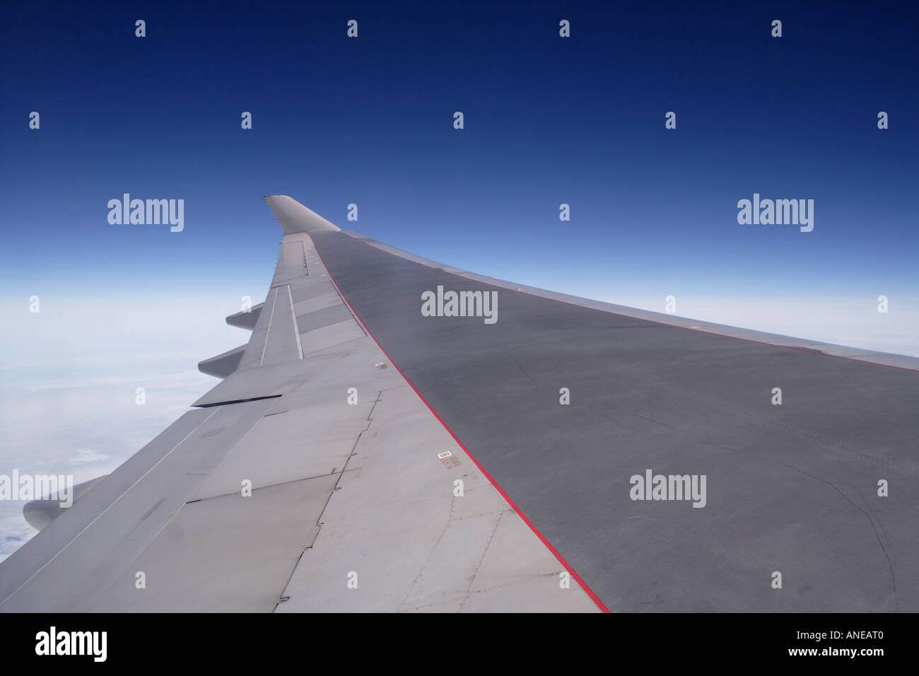 Aviogetti ala di aeroplano in volo sopra le nuvole Foto Stock