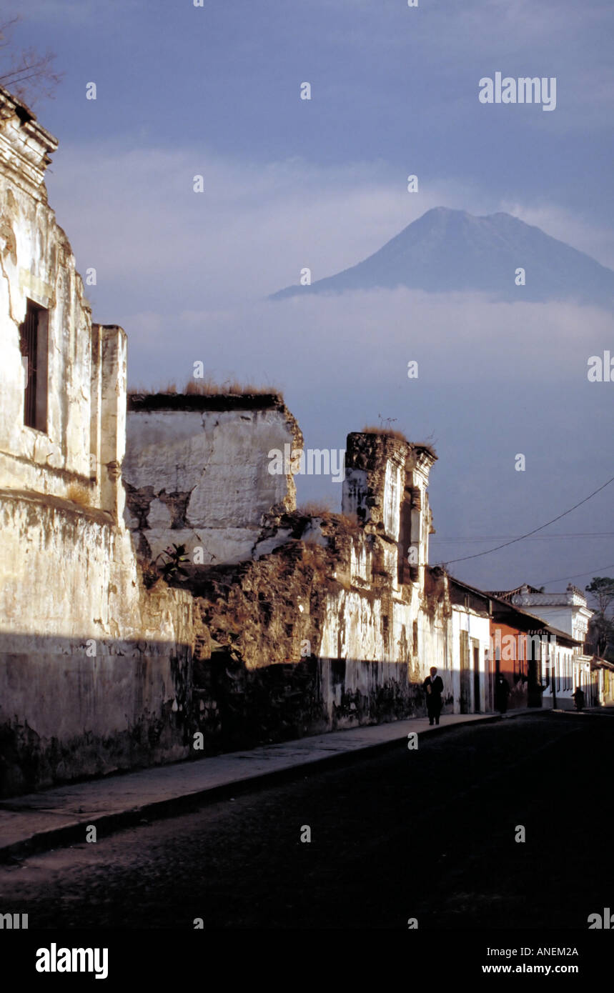 Volcan Agua galleggianti minacciosamente su strada con edifici distrutti Antigua Guatemala Foto Stock