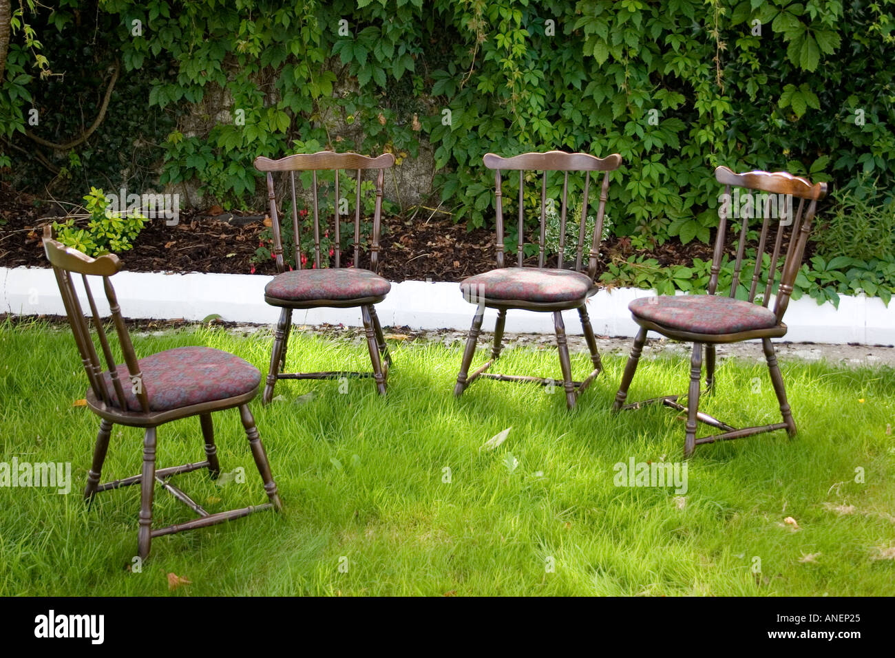 Quattro vuoto dritto indietro sedie di legno in giardino. Tipperary, Irlanda. Foto Stock