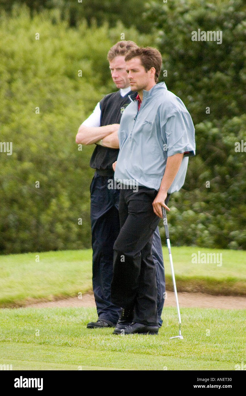 La star del calcio Michael Owen sul campo da golf con caddy. Foto Stock