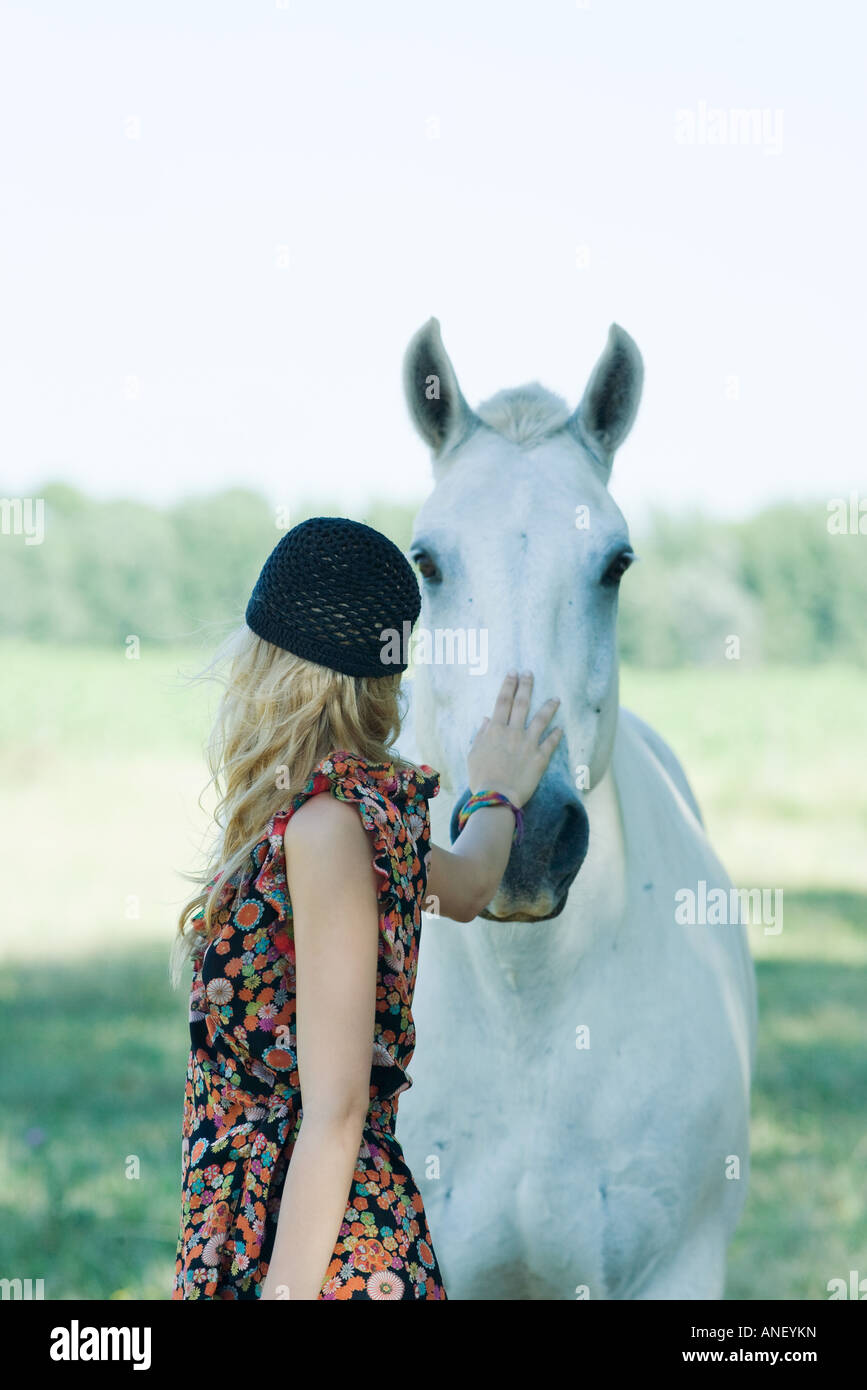 Giovane donna toccando cavallo Foto Stock