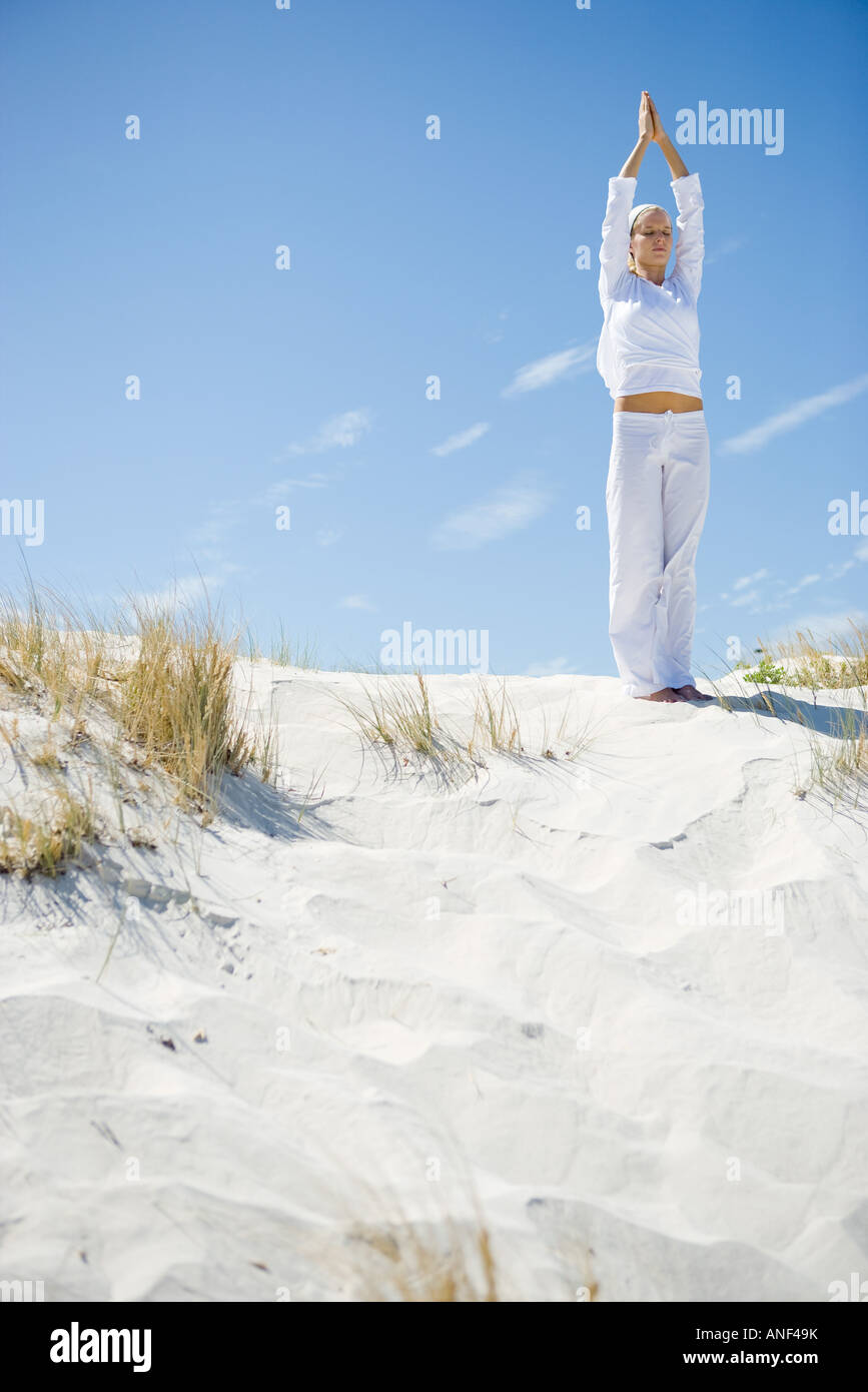 Giovane donna fare yoga sulla spiaggia a piena lunghezza Foto Stock
