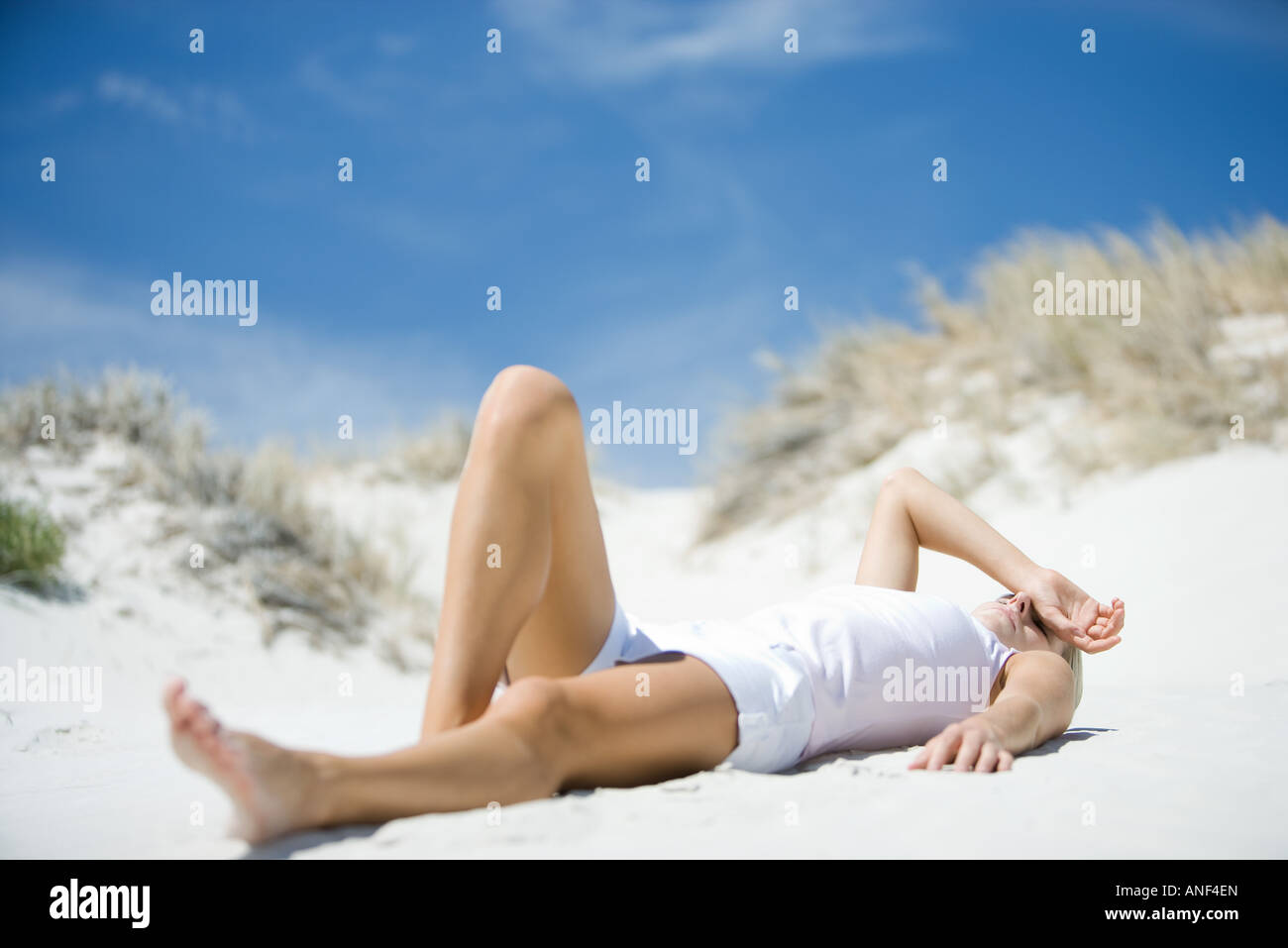 Giovane donna sdraiata sulla spiaggia Foto Stock