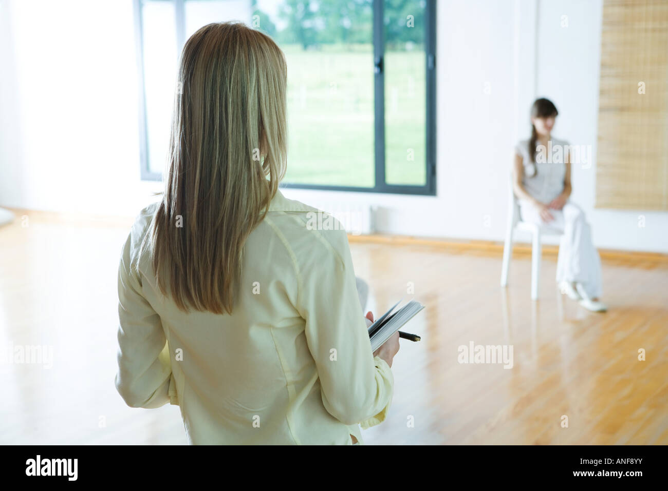 Donna che portano la terapia di gruppo sessione, vista posteriore, ritagliato Foto Stock