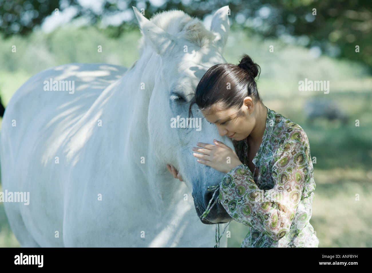 Giovane donna appoggiata la testa contro cavallo Foto Stock