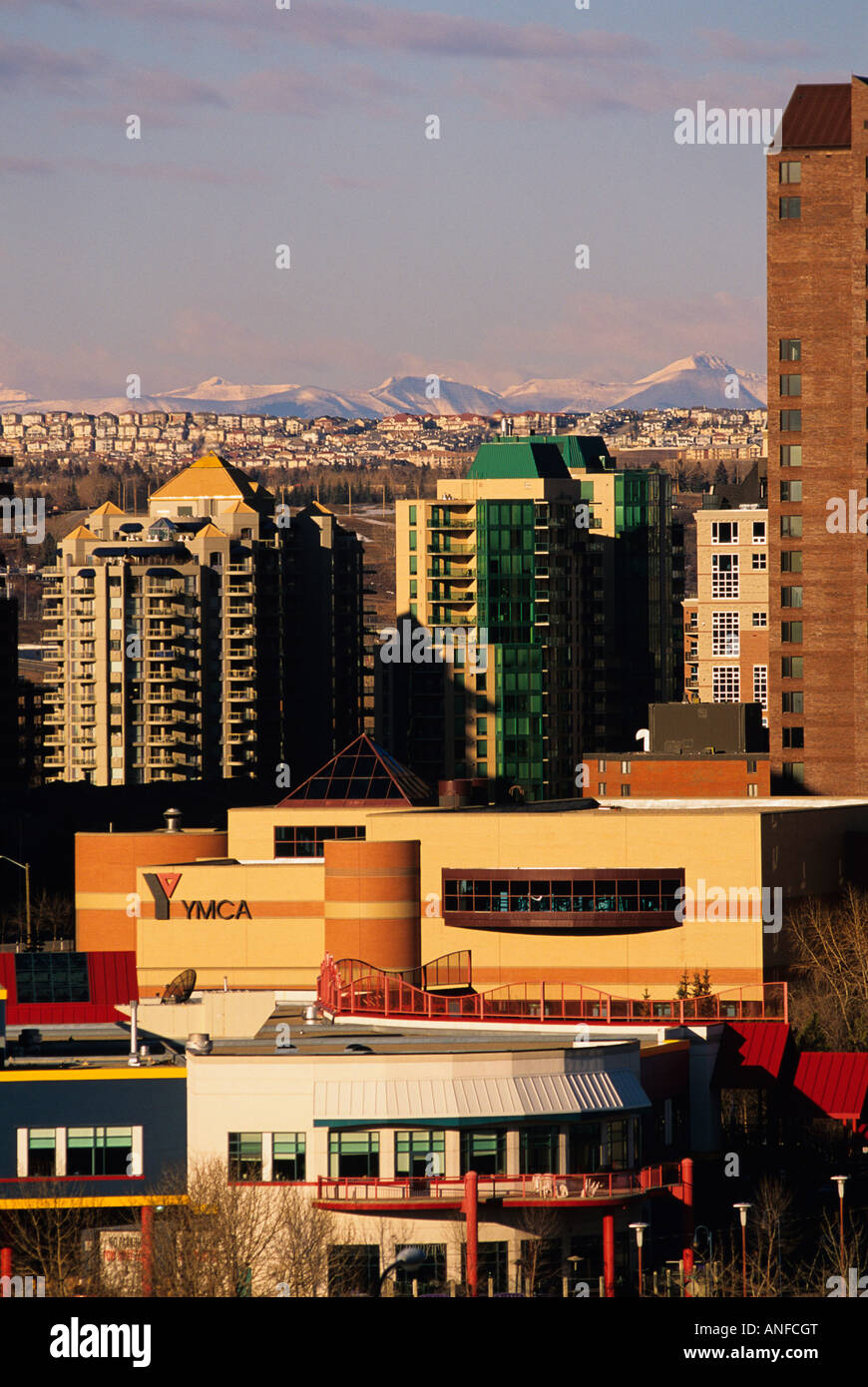 Il centro di edifici con zona residenziale e Montagne Rocciose in background, Calgary, Alberta, Canada Foto Stock