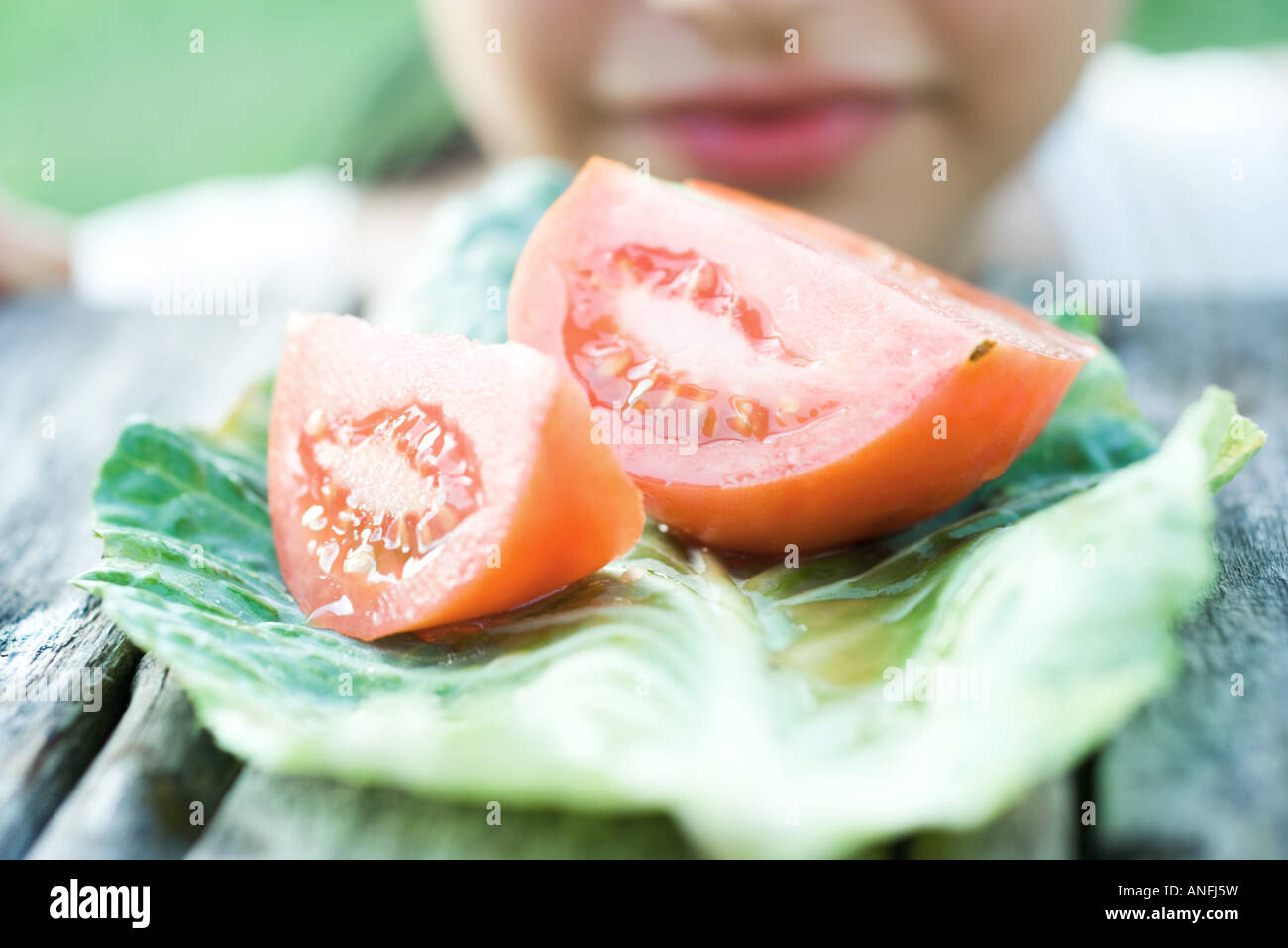 Fette di pomodoro, donna in background Foto Stock