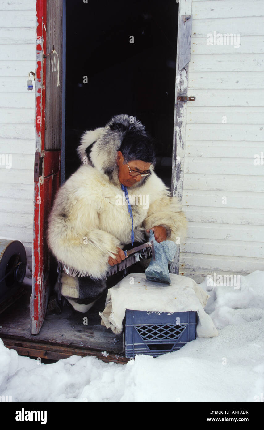 Anziano Inuit opere su pietra ollare carving in abbigliamento tradizionale, Kimmirut, Isola Baffin, Nunavut, Canada. Foto Stock