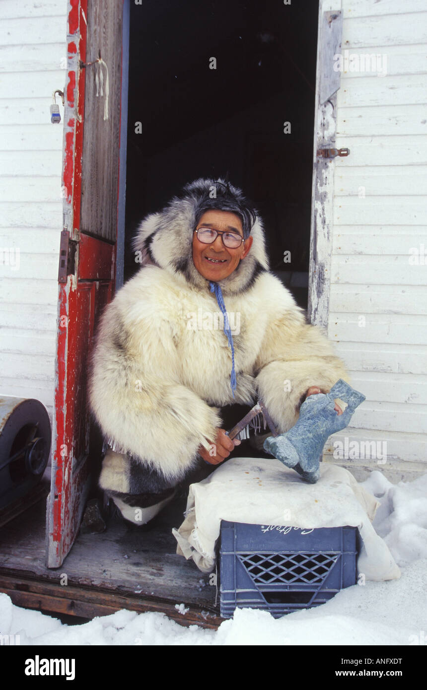 Anziano Inuit opere su pietra ollare carving in abbigliamento tradizionale, Kimmirut, Isola Baffin, Nunavut, Canada. Foto Stock