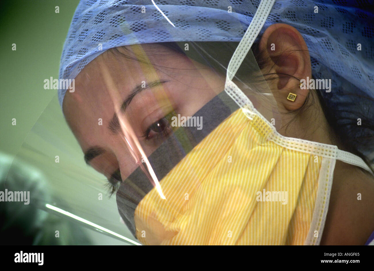 Asian nurse vestito in scrubs funziona con il resto del team di chirurgia REGNO UNITO Foto Stock
