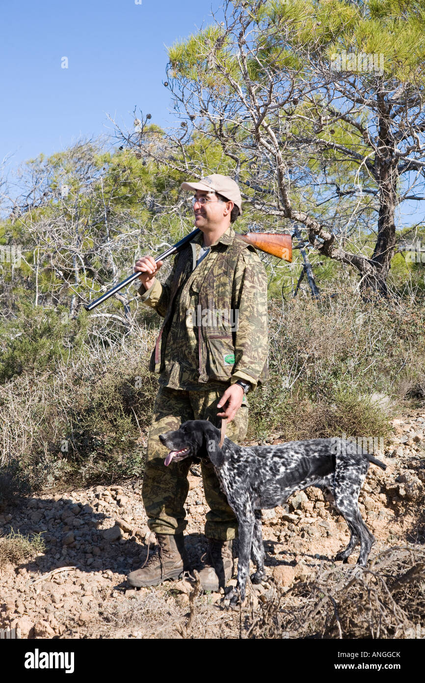 Un cacciatore cipriota primavera migratori uccello Sparatutto con Shotgun; Songbird tiro e caccia nella penisola di Akamas, Pafo, Cipro, Foto Stock