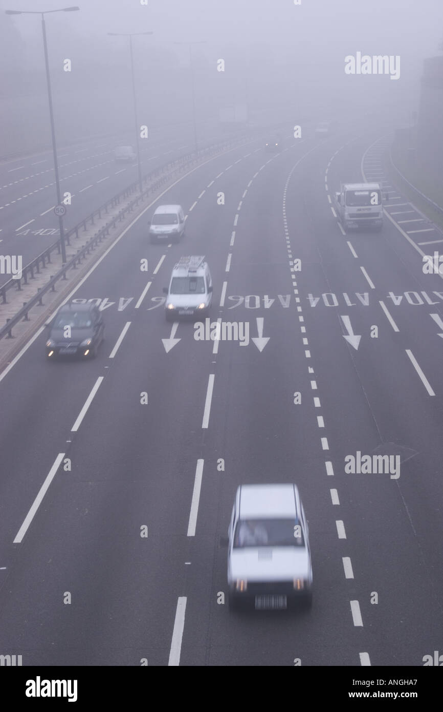 Il traffico nella nebbia del traffico in autostrada sulla corsia di sei A406 in foggy le condizioni del traffico Foto Stock