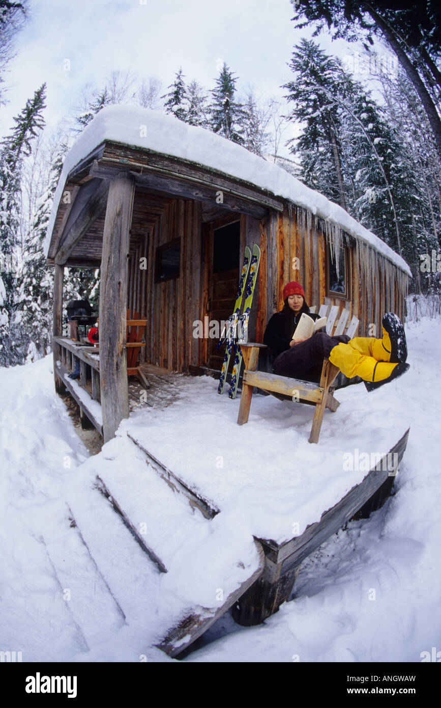 Un youn donna godendo il suo libro dopo una mattina tour di sci nella gamma Blaeberry, Golden, British Columbia, Canada Foto Stock