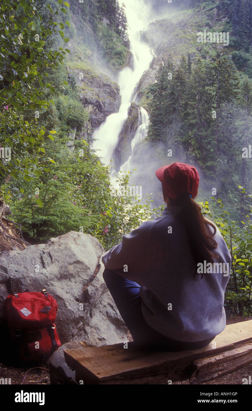 Escursionista affacciato sulla cascata nella costa centrale nella foresta pluviale, British Columbia, Canada. Foto Stock